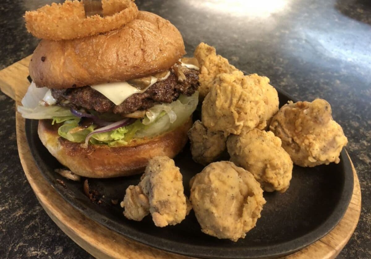 A hand-pattied half-pound Wimpy Burger with an onion ring on top