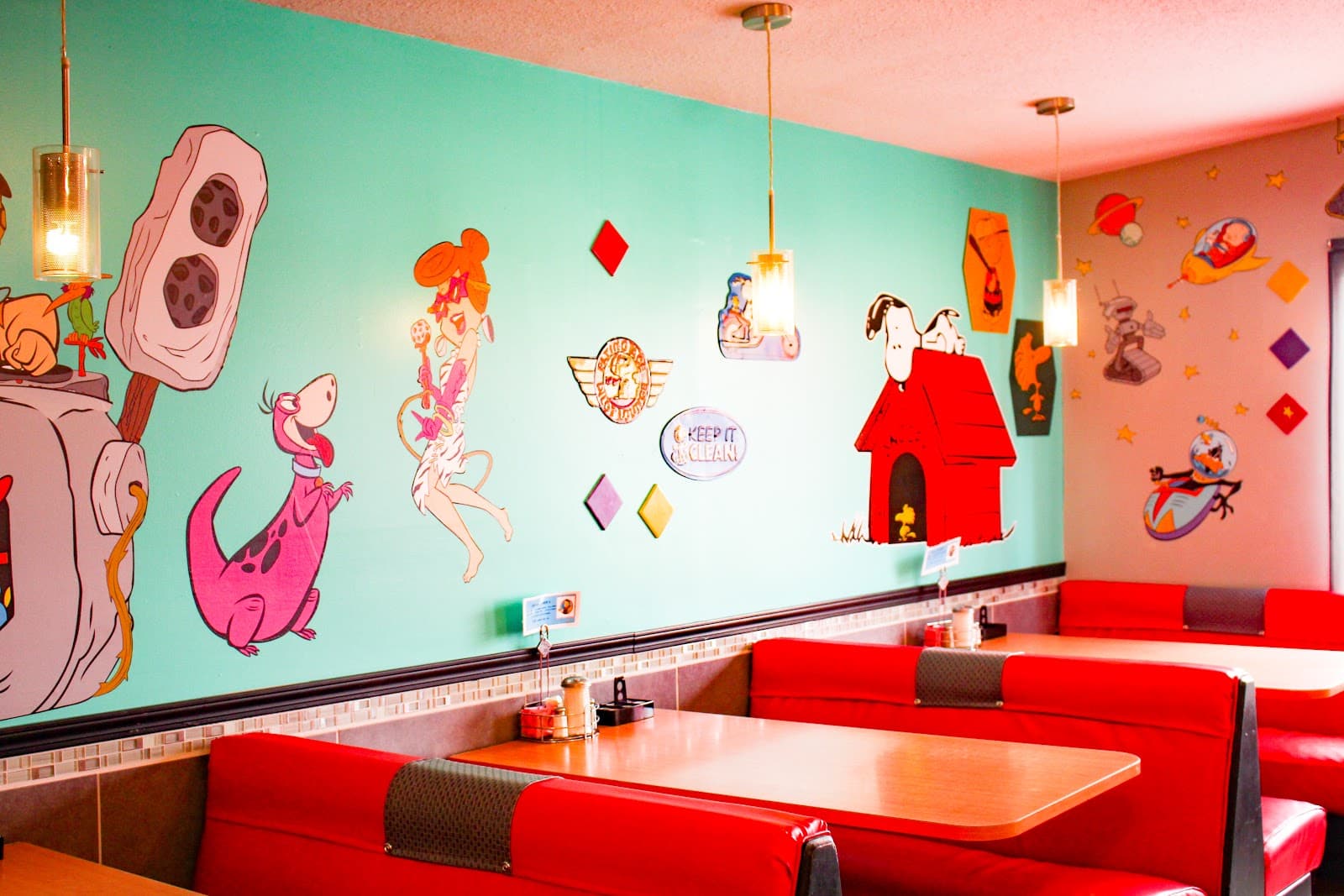 The painted mural over the booths at Funny Pages Cafe